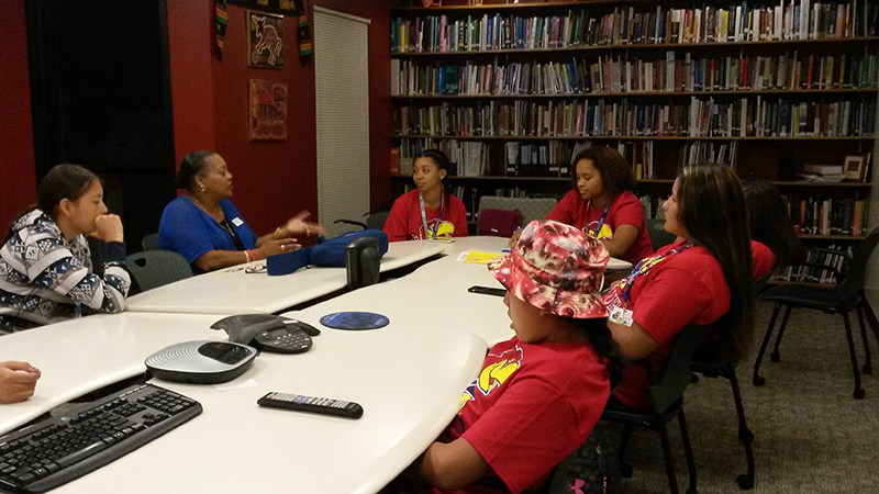 Group of students sitting around a conference table.