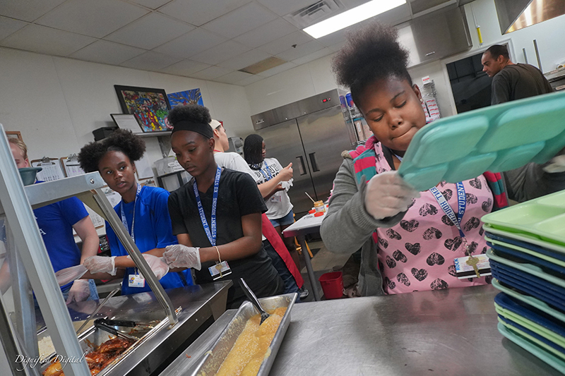 Image of Black young women working in an industrial kitchen.